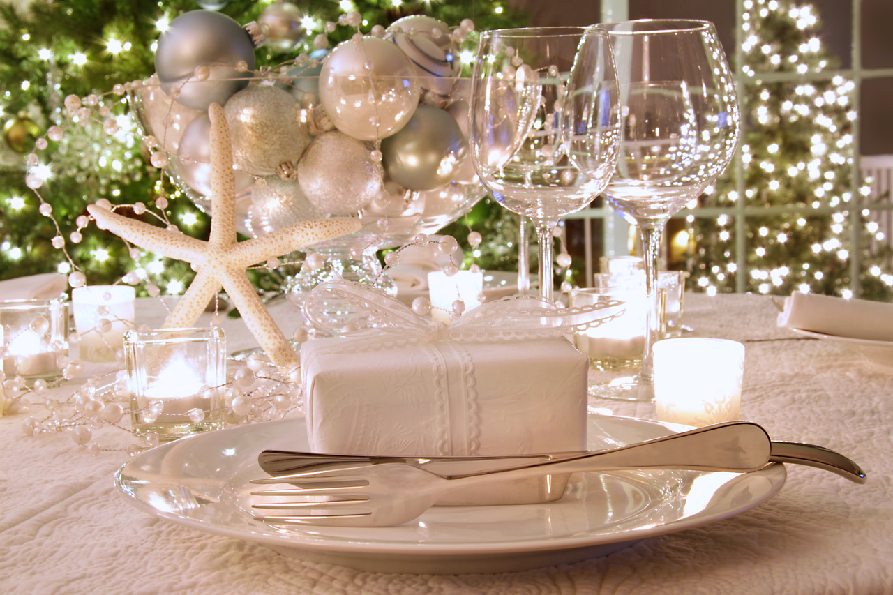 Elegantly lit  holiday dinner table with white ribbon gift